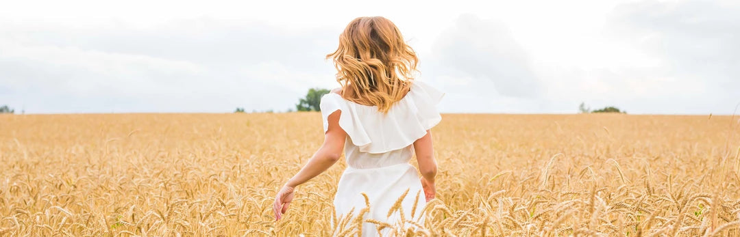 ragazza con vestito bianco nel campo di grano