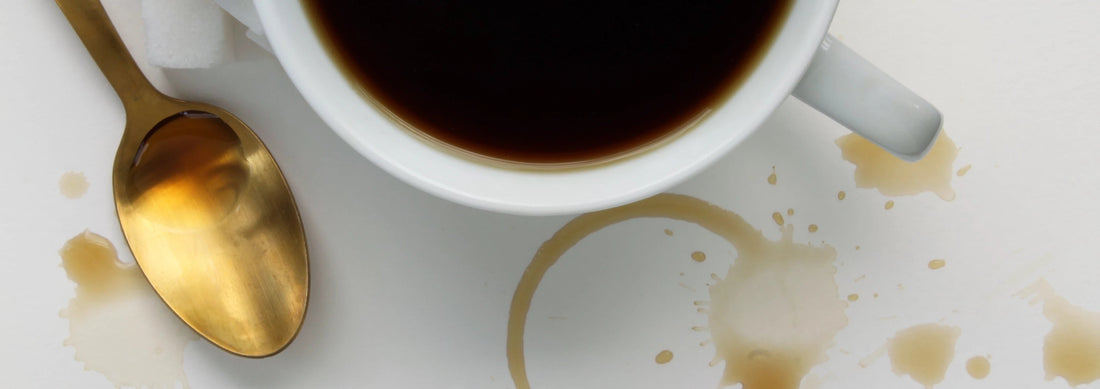 caffè con cucchiaio dorato e macchie