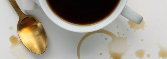 caffè con cucchiaio dorato e macchie